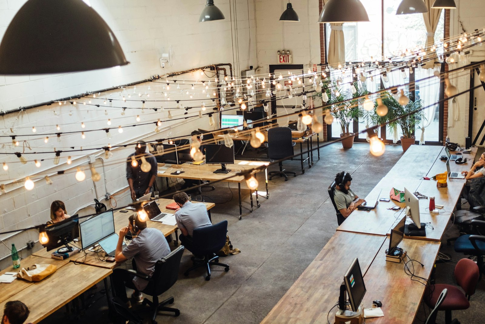 Coworking-Space in Berlin mit Menschen an gemeinsamen Tischen