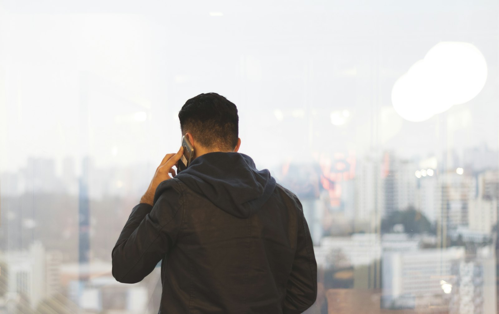 Selbstständiger telefoniert vor der Berliner Skyline